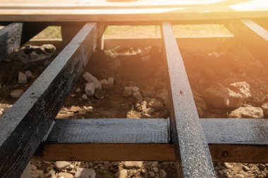 Terasın ahşap çerçevesine bituminöz astar takıyorum. Ahşap parmaklıklar ve tahtalar su geçirmez. Su geçirmez tahta.