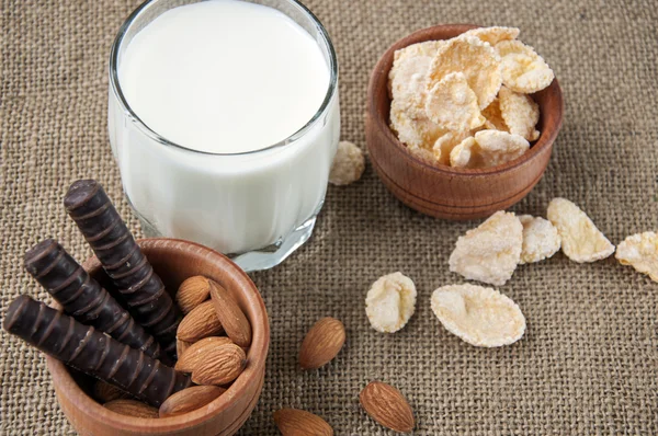 Vaso Leche Con Nueces Almendras Hojuelas Maíz Chocolates Sobre Fondo —  Fotos de Stock