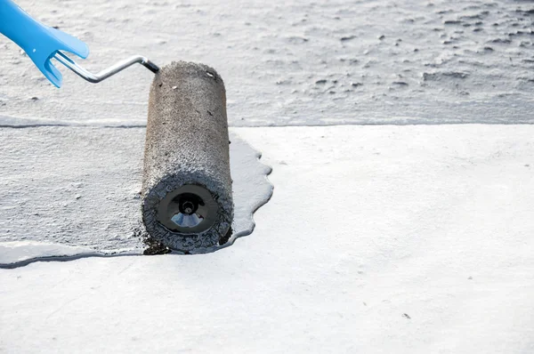 Roofer worker painting  bitumen praimer at concrete surface by t — Stock Photo, Image