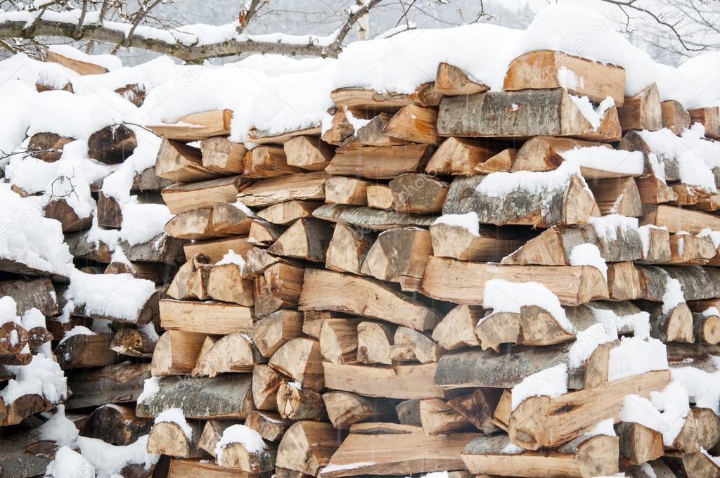 Stacked wood covered with snow. Background.