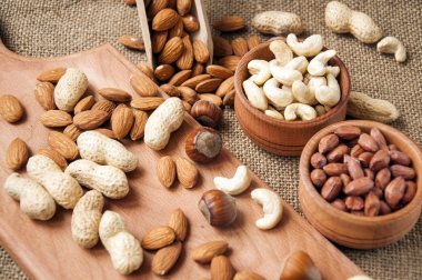 Badem, kaju ve fındık üzerinde ahşap Ahşap kase ve çuval bezi arka plan