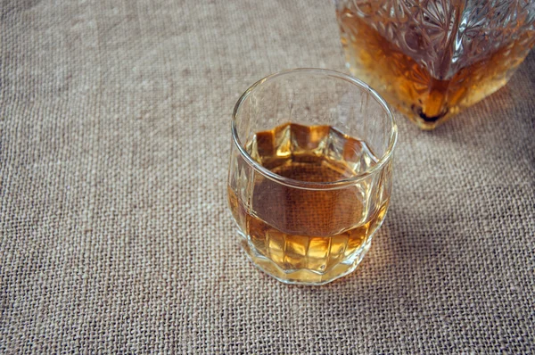 Karaf glas whisky en whiskey bourbon op een jute, zakken achtergrond — Stockfoto