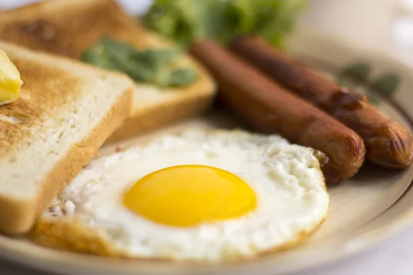 อาหารเช้าเพื่อสุขภาพ ไข่ทอด ไข่แดงเหลือง ขนมปังขนมปัง ไส้กรอก ผักในตอนเช้า — ภาพถ่ายสต็อก