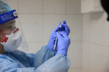 BUCHAREST, ROMANIA - 27 Aralık 2020: Bir hemşire Avrupa Aşı Kampanyasının ilk gününde bir doz Pfizer-BioNTech COVID-19 aşısı hazırladı.