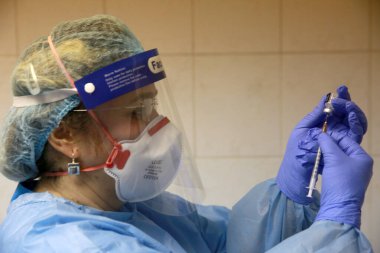 BUCHAREST, ROMANIA - 27 Aralık 2020: Bir hemşire Avrupa Aşı Kampanyasının ilk gününde bir doz Pfizer-BioNTech COVID-19 aşısı hazırladı.