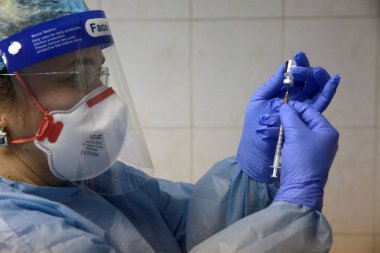 BUCHAREST, ROMANIA - 27 Aralık 2020: Bir hemşire Avrupa Aşı Kampanyasının ilk gününde bir doz Pfizer-BioNTech COVID-19 aşısı hazırladı.