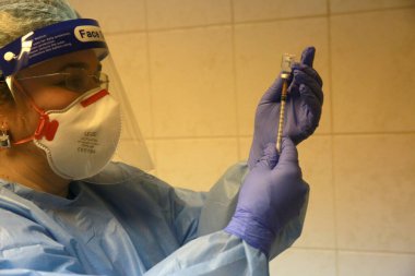 BUCHAREST, ROMANIA - 27 Aralık 2020: Bir hemşire Avrupa Aşı Kampanyasının ilk gününde bir doz Pfizer-BioNTech COVID-19 aşısı hazırladı.