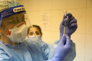 BUCHAREST, ROMANIA - 27 Aralık 2020: Bir hemşire Avrupa Aşı Kampanyasının ilk gününde bir doz Pfizer-BioNTech COVID-19 aşısı hazırladı.