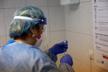 BUCHAREST, ROMANIA - 27 Aralık 2020: Bir hemşire Avrupa Aşı Kampanyasının ilk gününde bir doz Pfizer-BioNTech COVID-19 aşısı hazırladı.