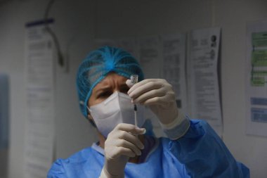 BUCHAREST, ROMANIA - 27 Aralık 2020: Bir hemşire Avrupa Aşı Kampanyasının ilk gününde bir doz Pfizer-BioNTech COVID-19 aşısı hazırladı.