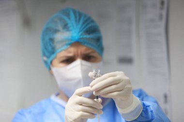 BUCHAREST, ROMANIA - 27 Aralık 2020: Bir hemşire Avrupa Aşı Kampanyasının ilk gününde bir doz Pfizer-BioNTech COVID-19 aşısı hazırladı.