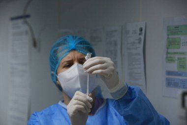 BUCHAREST, ROMANIA - 27 Aralık 2020: Bir hemşire Avrupa Aşı Kampanyasının ilk gününde bir doz Pfizer-BioNTech COVID-19 aşısı hazırladı.