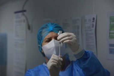 BUCHAREST, ROMANIA - 27 Aralık 2020: Bir hemşire Avrupa Aşı Kampanyasının ilk gününde bir doz Pfizer-BioNTech COVID-19 aşısı hazırladı.