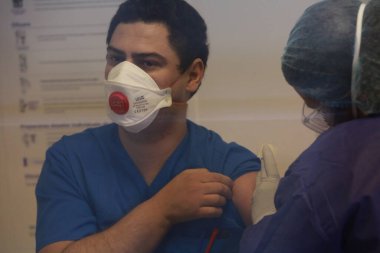 BUCHAREST, ROMANIA - 27 Aralık 2020: Avrupa Aşı Kampanyası 'nın ilk gününde bir tıp personeli covid aşıyı aldı.