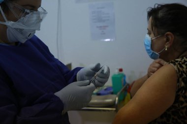 BUCHAREST, ROMANIA - 27 Aralık 2020: Avrupa Aşı Kampanyası 'nın ilk gününde bir tıp personeli covid aşıyı aldı.