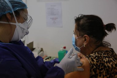 BUCHAREST, ROMANIA - 27 Aralık 2020: Avrupa Aşı Kampanyası 'nın ilk gününde bir tıp personeli covid aşıyı aldı.