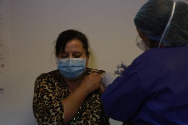 BUCHAREST, ROMANIA - 27 Aralık 2020: Avrupa Aşı Kampanyası 'nın ilk gününde bir tıp personeli covid aşıyı aldı.