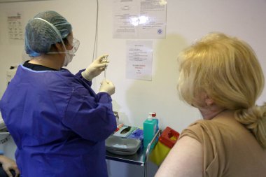 BUCHAREST, ROMANIA - 27 Aralık 2020: Avrupa Aşı Kampanyası 'nın ilk gününde bir tıp personeli covid aşıyı aldı.