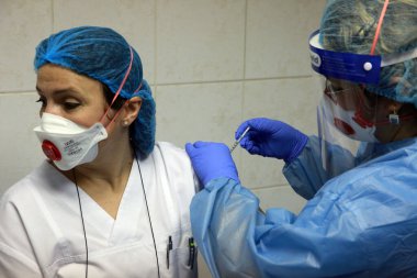 BUCHAREST, ROMANIA - 27 Aralık 2020: Avrupa Aşı Kampanyası 'nın ilk gününde bir tıp personeli covid aşıyı aldı.