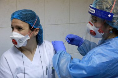 BUCHAREST, ROMANIA - 27 Aralık 2020: Avrupa Aşı Kampanyası 'nın ilk gününde bir tıp personeli covid aşıyı aldı.
