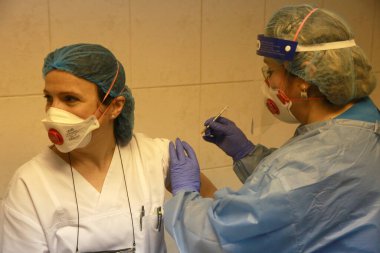 BUCHAREST, ROMANIA - 27 Aralık 2020: Avrupa Aşı Kampanyası 'nın ilk gününde bir tıp personeli covid aşıyı aldı.