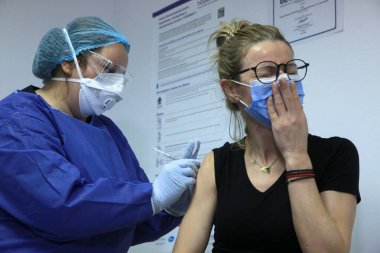 BUCHAREST, ROMANIA - 27 Aralık 2020: Avrupa Aşı Kampanyası 'nın ilk gününde bir tıp personeli covid aşıyı aldı.