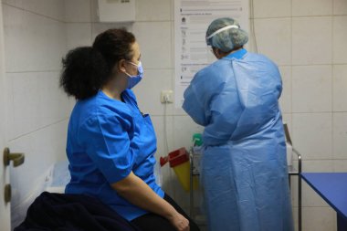 BUCHAREST, ROMANIA - 27 Aralık 2020: Avrupa Aşı Kampanyası 'nın ilk gününde bir tıp personeli covid aşıyı aldı.