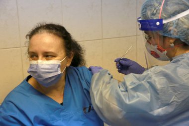 BUCHAREST, ROMANIA - 27 Aralık 2020: Avrupa Aşı Kampanyası 'nın ilk gününde bir tıp personeli covid aşıyı aldı.