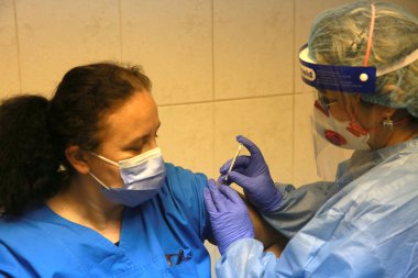 BUCHAREST, ROMANIA - 27 Aralık 2020: Avrupa Aşı Kampanyası 'nın ilk gününde bir tıp personeli covid aşıyı aldı.