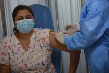 BUCHAREST, ROMANIA - 27 Aralık 2020: Avrupa Aşı Kampanyası 'nın ilk gününde bir tıp personeli covid aşıyı aldı.