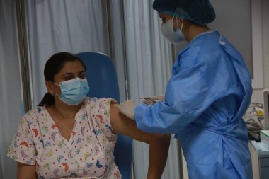 BUCHAREST, ROMANIA - 27 Aralık 2020: Avrupa Aşı Kampanyası 'nın ilk gününde bir tıp personeli covid aşıyı aldı.