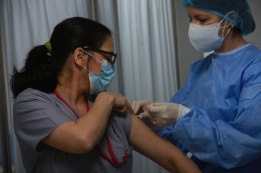 BUCHAREST, ROMANIA - 27 Aralık 2020: Avrupa Aşı Kampanyası 'nın ilk gününde bir tıp personeli covid aşıyı aldı.