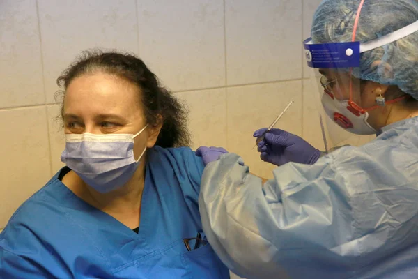 BUCHAREST, ROMANIA - 27 Aralık 2020: Avrupa Aşı Kampanyası 'nın ilk gününde bir tıp personeli covid aşıyı aldı.