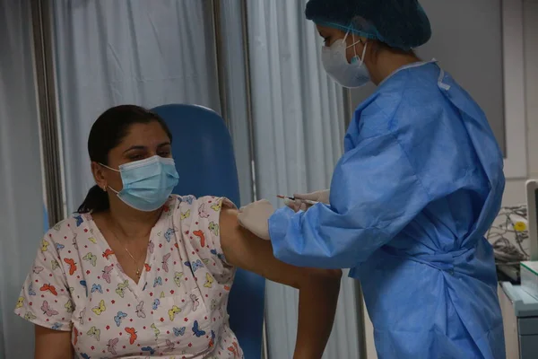 BUCHAREST, ROMANIA - 27 Aralık 2020: Avrupa Aşı Kampanyası 'nın ilk gününde bir tıp personeli covid aşıyı aldı.