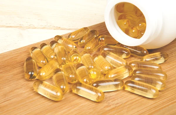 Cod ulei de ficat omega 3 capsule de gel pe biroul de masă din lemn izolat pe fundal alb — Fotografie, imagine de stoc