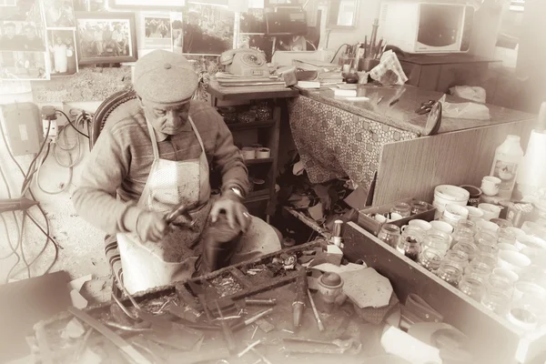 Szewc w pracy przy użyciu tradycyjnych narzędzi stary Nicosia, Cypr - krajobraz — Zdjęcie stockowe