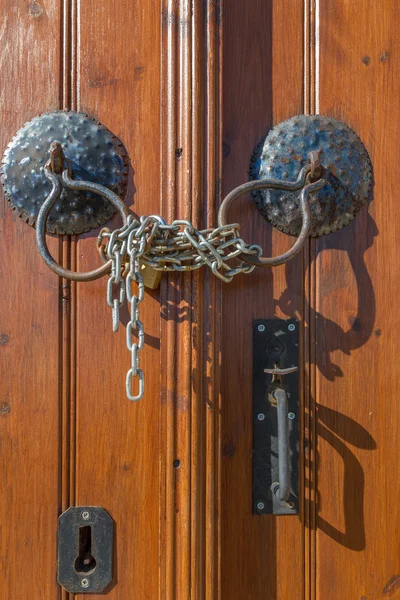 Manillas de puerta de madera marrón viejo, cadena y cerradura — Foto de Stock