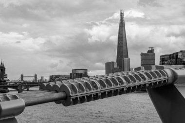 Millennium Footbridge 'in arkasındaki ufuk çizgisine hakim olan Çömlek Simgesi binası. Londra Köprüsü de uzaktan görülebilir..