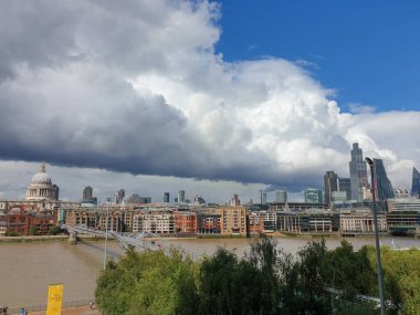 Londra, Birleşik Krallık - 30 Temmuz 2021: Thames, St Paul Katedrali ve Londra şehri, Tate Modern Galerisi 'nde görülen dramatik gökyüzüne karşı bir iş alanı.