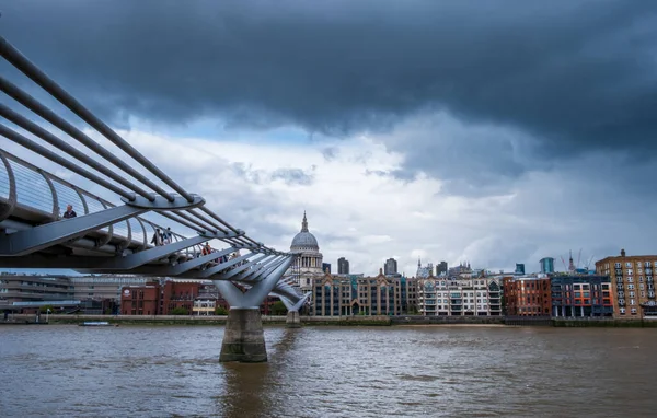 ロンドン イギリス 2021年7月30日 嵐の空の開口部を通して聖ポール大聖堂に向かって導くミレニアム フットブリッジの眺め — ストック写真