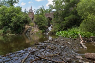 Eski Köprü, şelale ve ağaç dalları ön planda