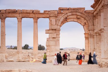 Visitors walking in the Ruins of the ancient city of Palmyra, Syrian Desert clipart