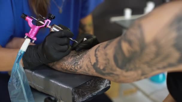 Fille tatoueuse tatouant son client — Video