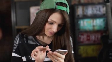 telefon ile kaykay üzerinde oturan kız