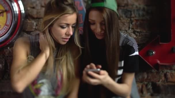 Две счастливые девушки фотографируются со своим смартфоном в комнате — стоковое видео