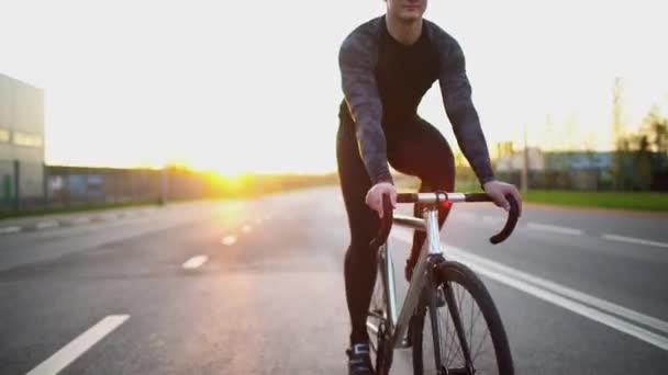 Man som Red fixed gear cykel på vägen vid solnedgången — Stockvideo