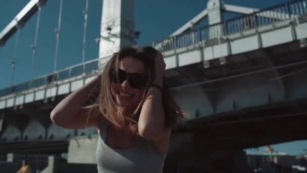 Chica feliz corre en el fondo del puente en cámara lenta — Vídeos de Stock