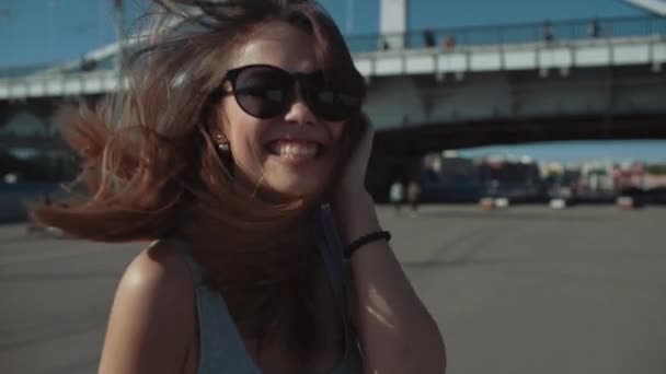 Menina feliz corre no fundo da ponte em câmera lenta — Vídeo de Stock