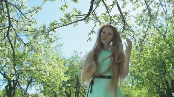 Girl with long red hair in apple garden — Stock Video