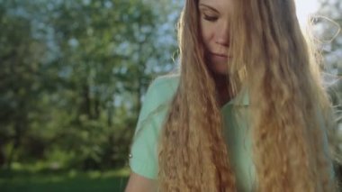 Tablet elma bahçesinde uzun kızıl saçlı kız bakar